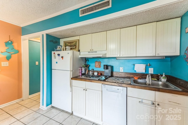 415 Ocean Creek Dr N Unit 2330, Myrtle Beach, SC 29572 - kitchen featuring white appliances, under cabinet range hood, a sink, a textured ceiling, and light tile patterned floors