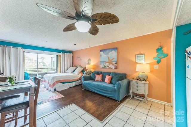 415 Ocean Creek Dr N Unit 2330, Myrtle Beach, SC 29572 - bedroom featuring light tile patterned floors, a textured ceiling, a ceiling fan, and baseboards