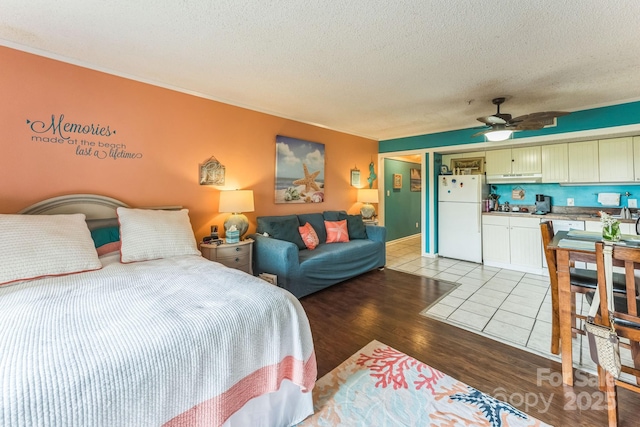 415 Ocean Creek Dr N Unit 2330, Myrtle Beach, SC 29572 - bedroom with freestanding refrigerator, a textured ceiling, light wood-style flooring, ornamental molding, and a ceiling fan