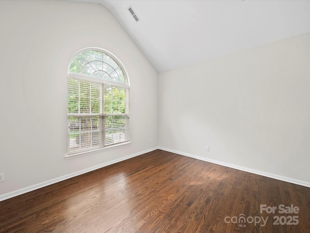 unfurnished room with visible vents, wood finished floors, lofted ceiling, and baseboards