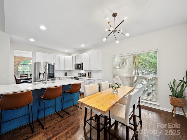 dining area with recessed lighting, a notable chandelier, dark wood-style floors, and baseboards