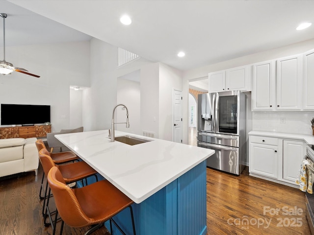 kitchen featuring white cabinets, ceiling fan, stainless steel fridge with ice dispenser, and a sink