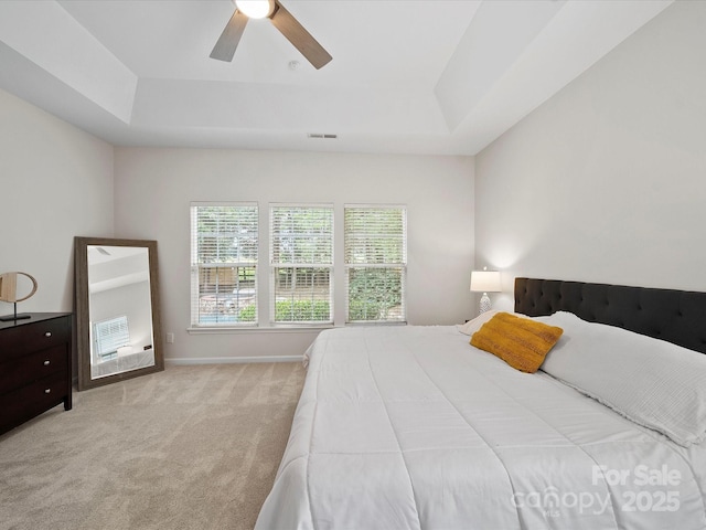 bedroom featuring a raised ceiling, ceiling fan, visible vents, and carpet floors