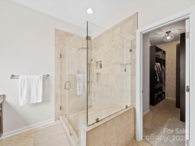 full bathroom featuring recessed lighting, a walk in closet, vanity, baseboards, and a stall shower