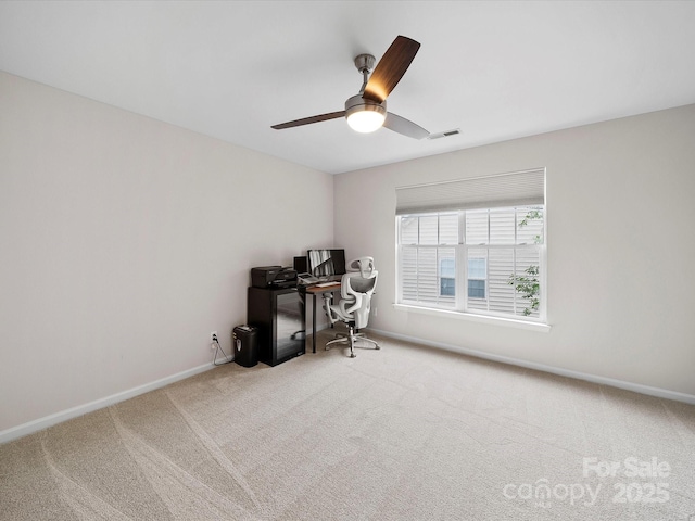carpeted home office featuring a ceiling fan, visible vents, and baseboards