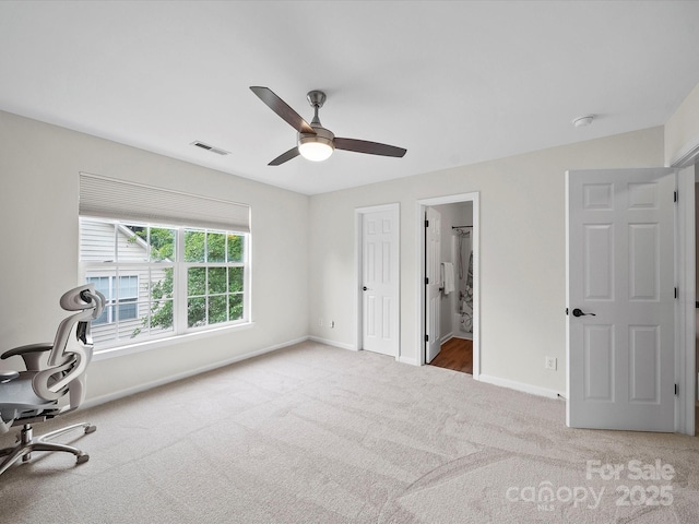unfurnished office featuring visible vents, ceiling fan, carpet floors, and baseboards