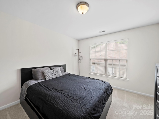 bedroom featuring light colored carpet, visible vents, and baseboards