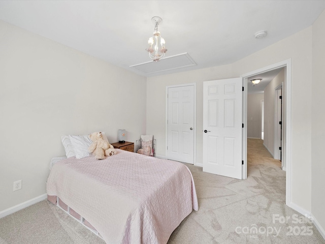 bedroom with attic access, baseboards, and light carpet