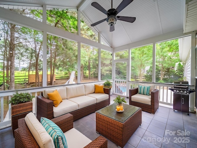 sunroom featuring an outdoor living space, ceiling fan, and a wealth of natural light