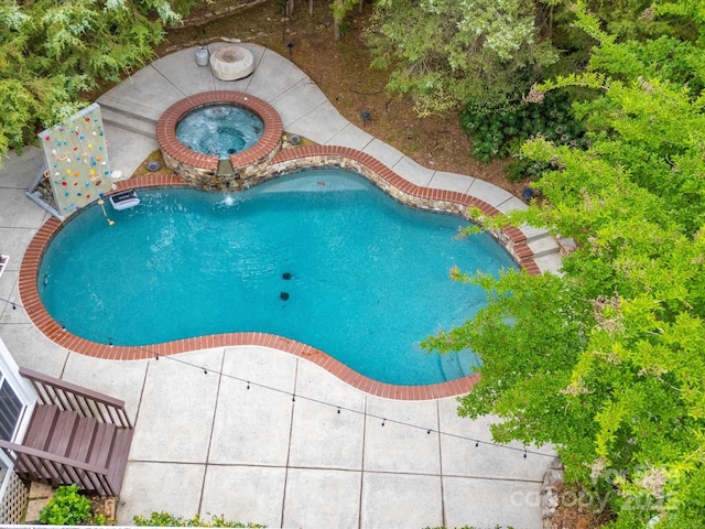 outdoor pool featuring a patio and an in ground hot tub