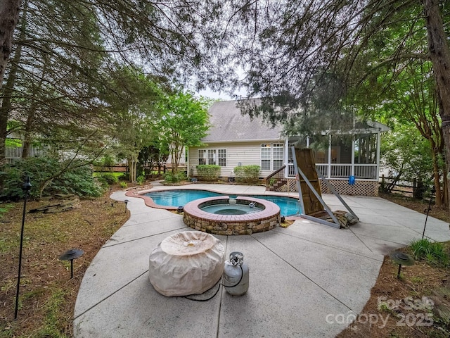 view of swimming pool featuring a patio area, a pool with connected hot tub, and a sunroom