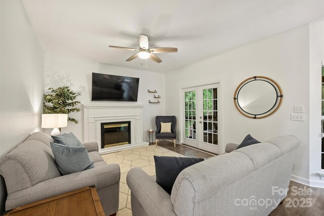 6723 Joliette Ln, Charlotte, NC 28277 - living area featuring ceiling fan, a glass covered fireplace, wood finished floors, baseboards, and french doors