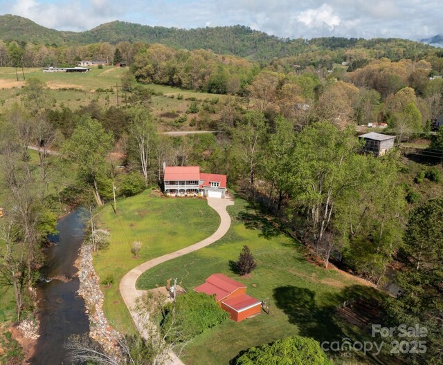 drone / aerial view with a mountain view, a rural view, and a wooded view