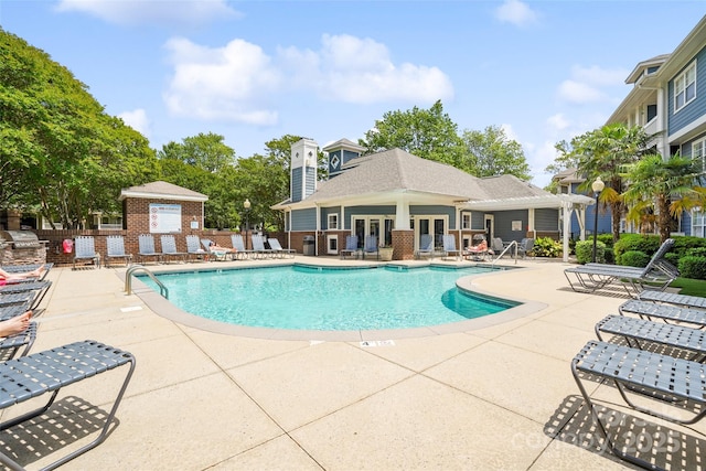 community pool with a patio area and french doors
