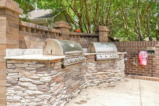 view of patio / terrace featuring exterior kitchen, grilling area, and fence