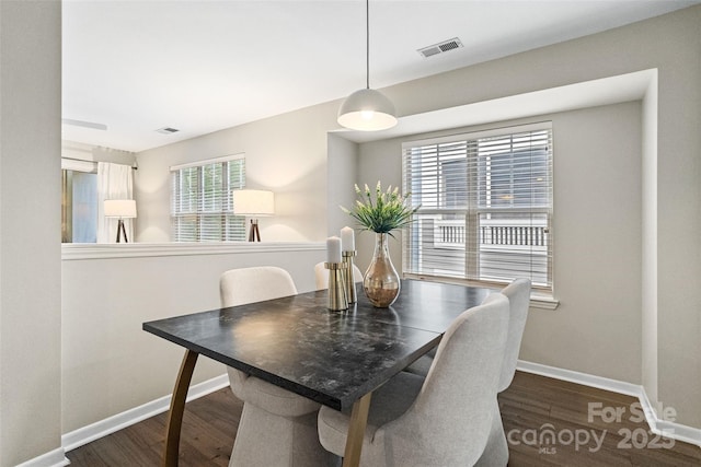 dining space with dark wood-style flooring and baseboards