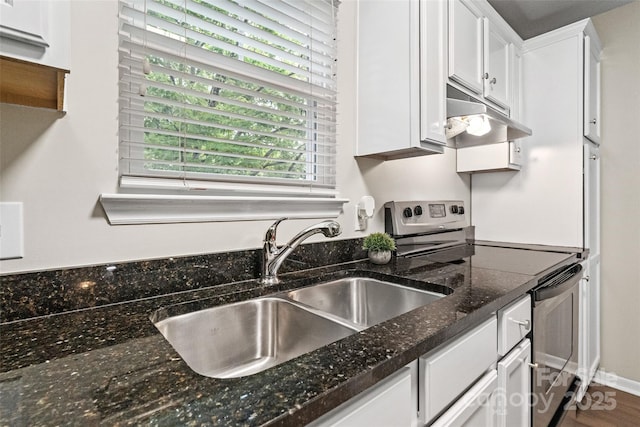 kitchen with stainless steel electric stove, under cabinet range hood, a sink, white cabinetry, and dark stone counters