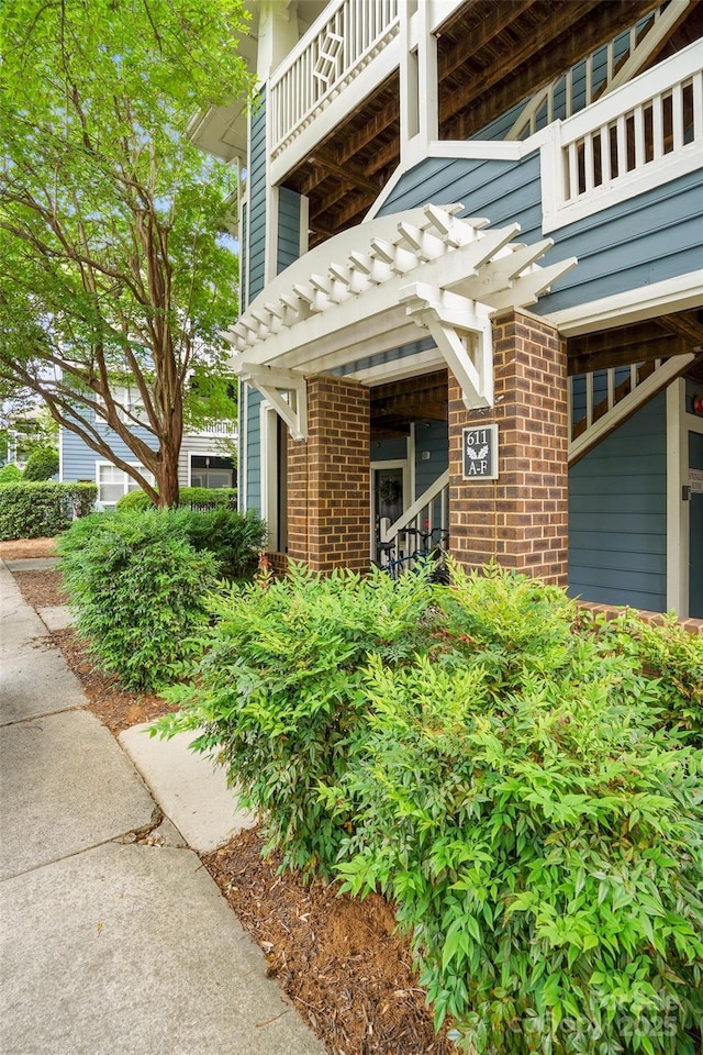 doorway to property with brick siding and a balcony