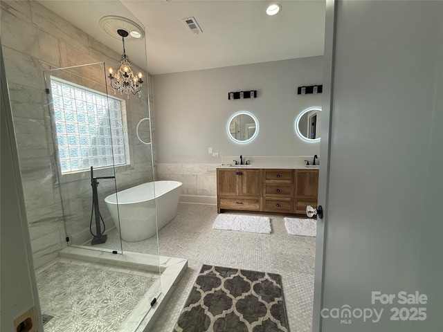 19409 Laurel Glen Ave, Cornelius, NC 28031 - full bath with tile walls, a freestanding tub, a chandelier, and a sink