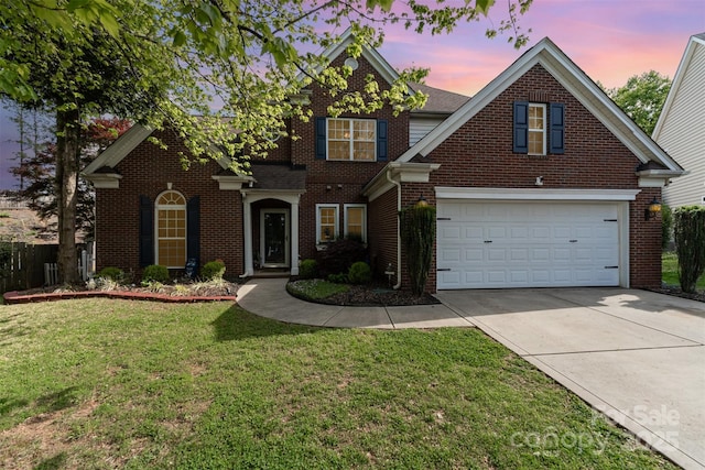 traditional home with a garage, brick siding, driveway, and a lawn