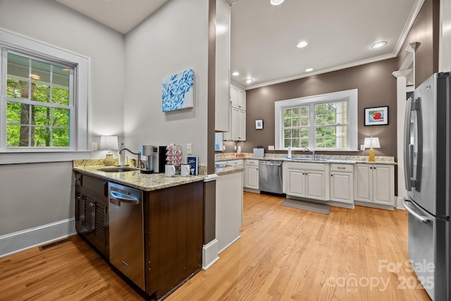 100 Poplar Spring Trl, Hendersonville, NC 28739 - kitchen featuring appliances with stainless steel finishes, white cabinetry, light wood-style floors, ornamental molding, and light stone countertops