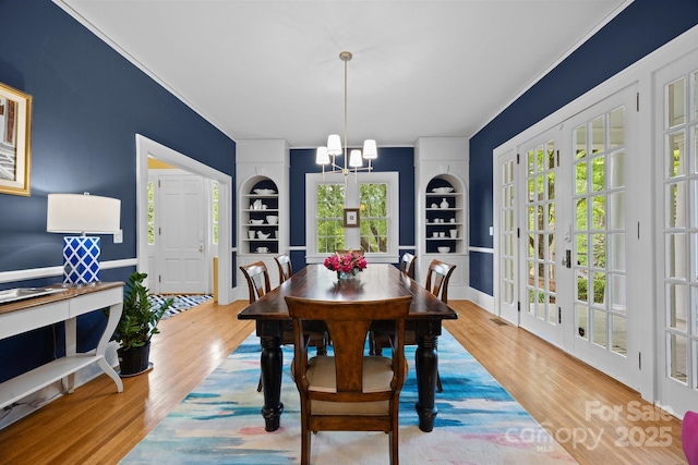 100 Poplar Spring Trl, Hendersonville, NC 28739 - dining room featuring a chandelier, built in features, wood finished floors, and ornamental molding