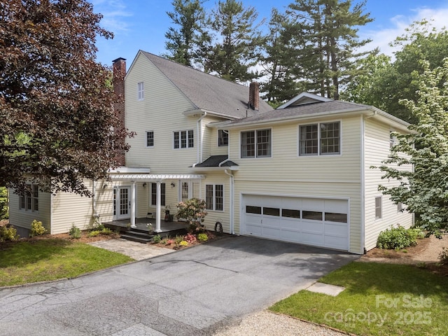 100 Poplar Spring Trl, Hendersonville, NC 28739 - traditional-style home featuring a chimney, asphalt driveway, an attached garage, and a front lawn