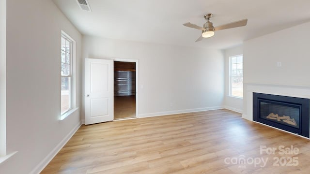 9612 Pointer Rd Unit 59, Huntersville, NC 28078 - unfurnished living room featuring light wood-type flooring, a glass covered fireplace, and ceiling fan