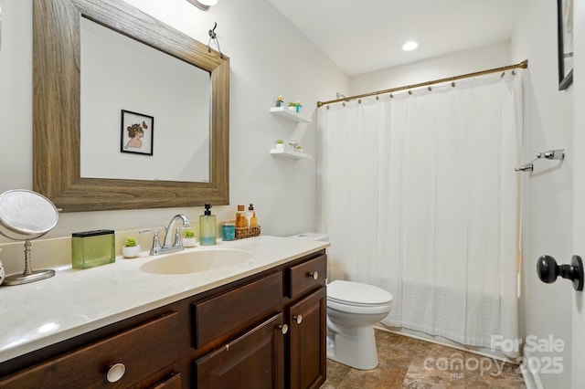 bathroom featuring vanity, stone finish floor, and toilet