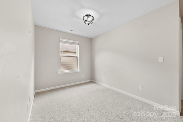 carpeted spare room with baseboards