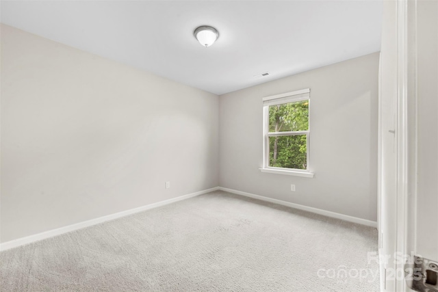spare room featuring baseboards and carpet floors