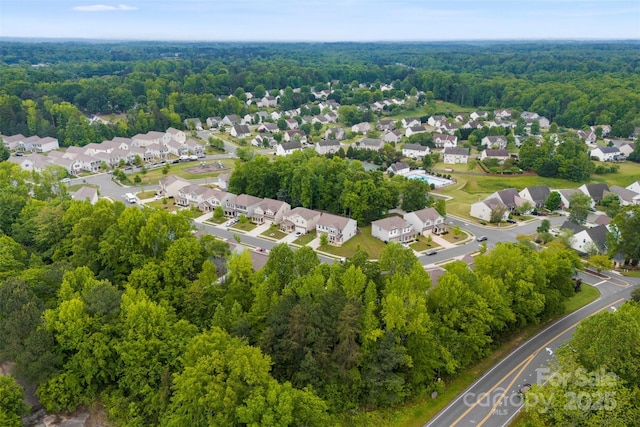 aerial overview of property's location with a heavily wooded area and nearby suburban area