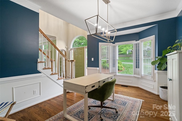home office with crown molding, a chandelier, a decorative wall, a wainscoted wall, and wood finished floors