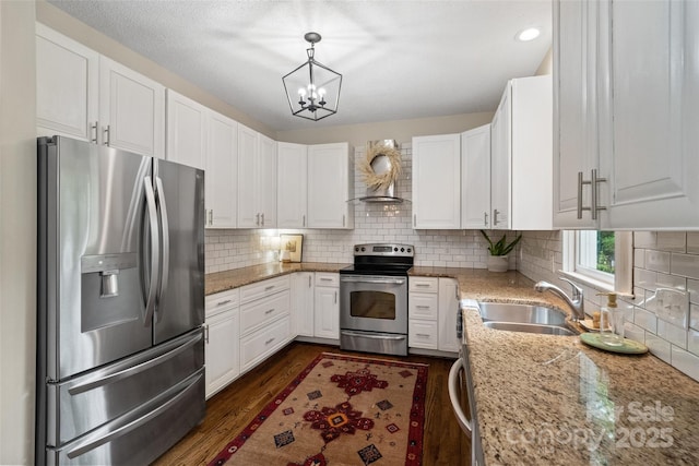 kitchen featuring a sink, stainless steel appliances, light stone counters, white cabinetry, and dark wood finished floors