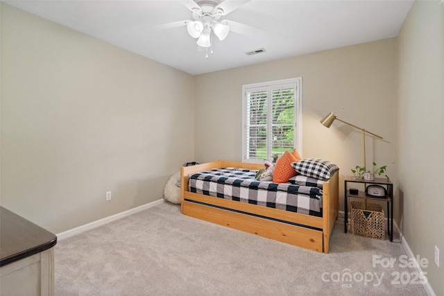 carpeted bedroom with visible vents, a ceiling fan, and baseboards