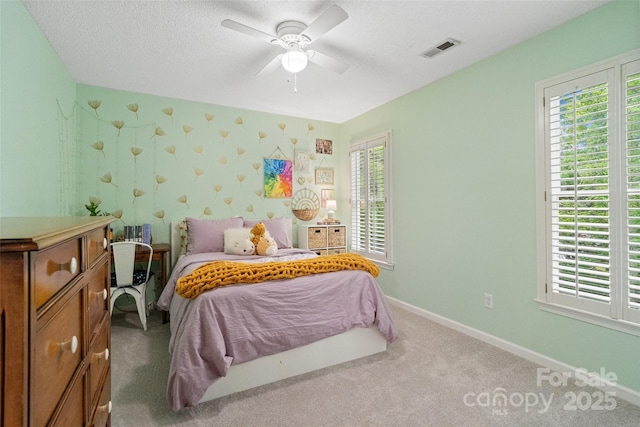 carpeted bedroom featuring baseboards, visible vents, and a ceiling fan