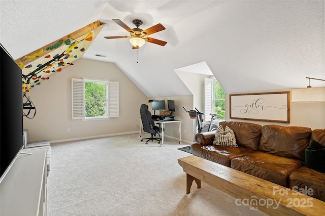 carpeted office space with ceiling fan, baseboards, lofted ceiling, and visible vents