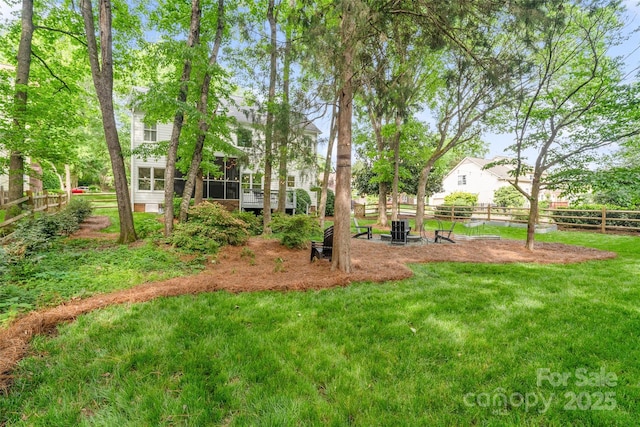 view of yard featuring fence and a sunroom