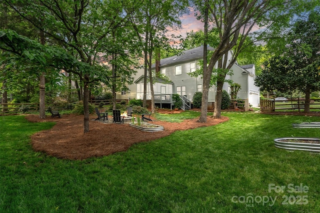 yard at dusk featuring fence and an outdoor fire pit