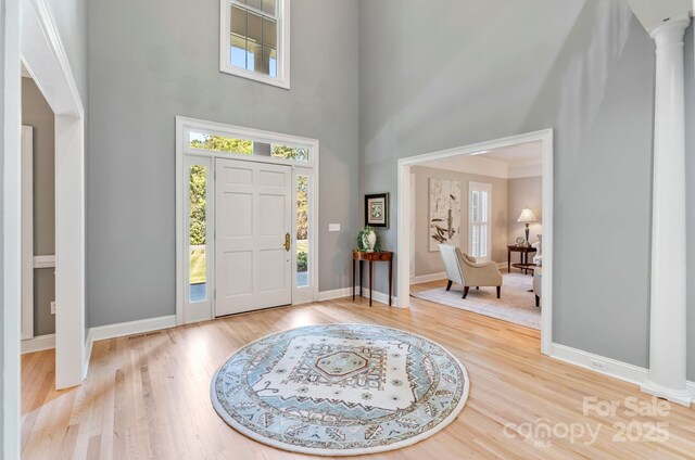 1721 White Pond Ln, Waxhaw, NC 28173 - entrance foyer with a towering ceiling, decorative columns, wood finished floors, and baseboards