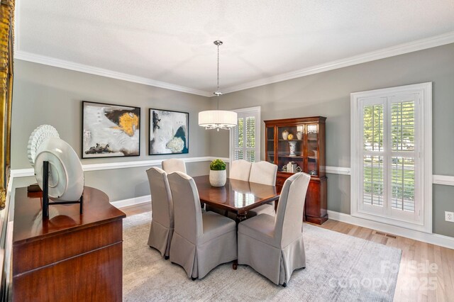 1721 White Pond Ln, Waxhaw, NC 28173 - dining room with a chandelier, light wood-type flooring, crown molding, and baseboards