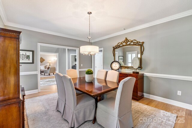 1721 White Pond Ln, Waxhaw, NC 28173 - dining area with light wood-style floors, a chandelier, crown molding, and baseboards