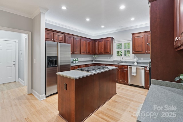 1721 White Pond Ln, Waxhaw, NC 28173 - kitchen featuring appliances with stainless steel finishes, light wood finished floors, ornamental molding, a sink, and a kitchen island