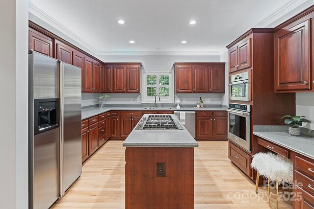 1721 White Pond Ln, Waxhaw, NC 28173 - kitchen featuring appliances with stainless steel finishes, ornamental molding, light wood-style floors, recessed lighting, and a kitchen island