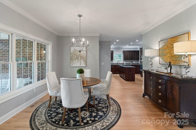 1721 White Pond Ln, Waxhaw, NC 28173 - dining room with light wood-type flooring, a chandelier, crown molding, baseboards, and recessed lighting
