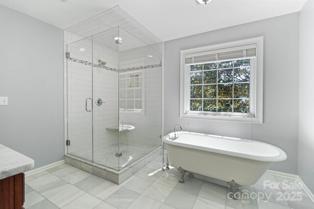 1721 White Pond Ln, Waxhaw, NC 28173 - full bathroom with a soaking tub, a stall shower, baseboards, and vanity