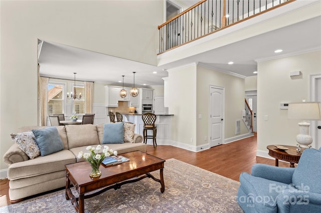 7923 Mountain Shore Dr, Sherrills Ford, NC 28673 - living room featuring stairway, a chandelier, ornamental molding, wood finished floors, and baseboards