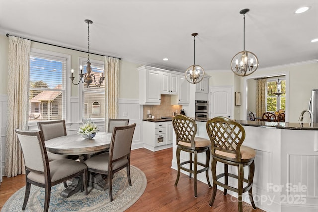 7923 Mountain Shore Dr, Sherrills Ford, NC 28673 - dining room with a chandelier, ornamental molding, dark wood-style flooring, recessed lighting, and a wainscoted wall
