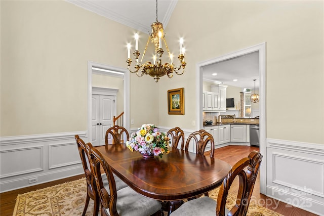 7923 Mountain Shore Dr, Sherrills Ford, NC 28673 - dining area featuring a chandelier, a wainscoted wall, dark wood-type flooring, crown molding, and a decorative wall
