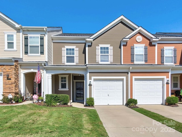 townhome / multi-family property with a garage, driveway, and a front yard
